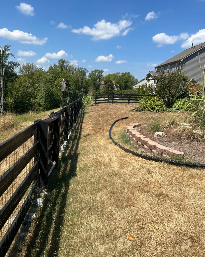 Dry lawn with landscape edging laid out before walkway installation beside a retaining wall bed in College Grove, Tennessee