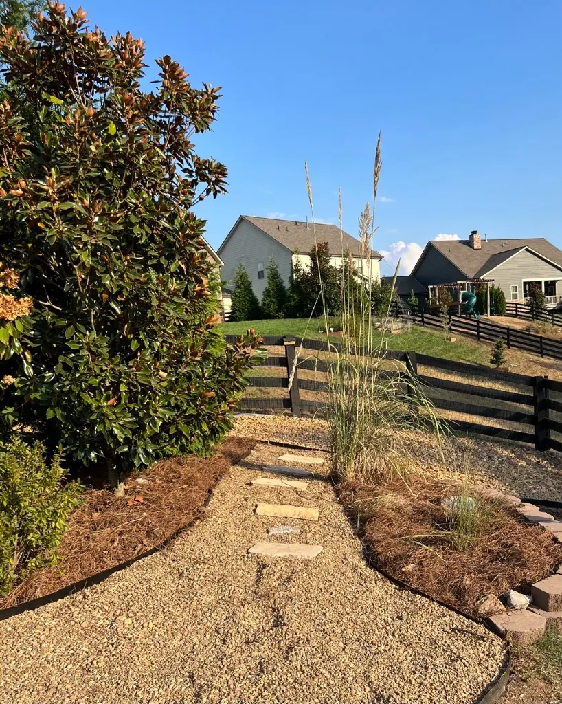 Pea gravel walkway with stepping stones and pine straw beds from the opposite side in College Grove, Tennessee