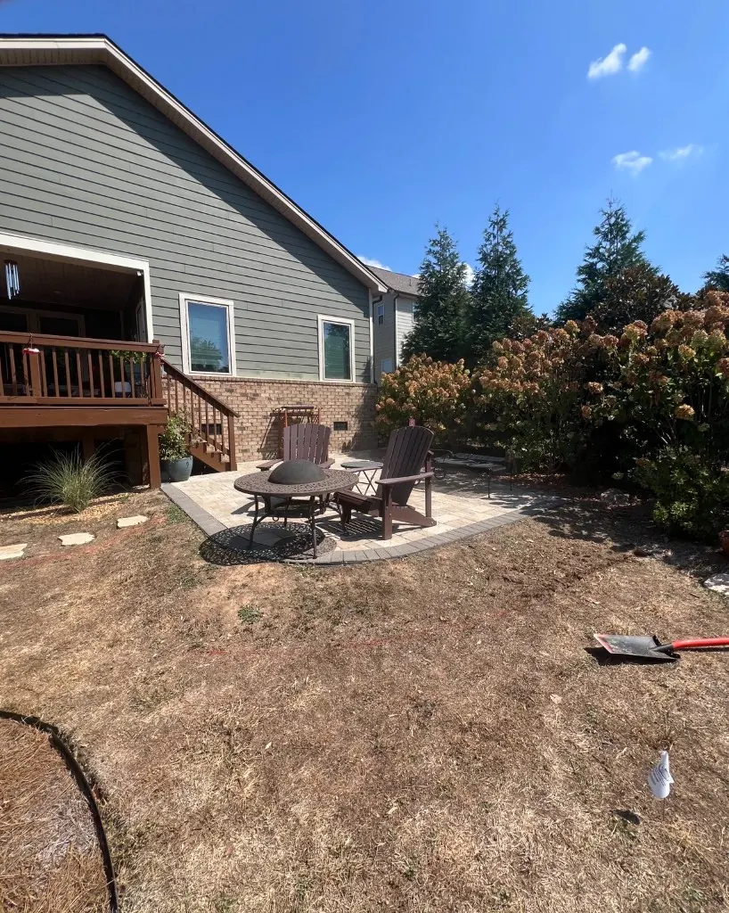 Patio edge with dry lawn and spray-paint layout before pea gravel bed and Black-Eyed Susan planting in College Grove, Tennessee