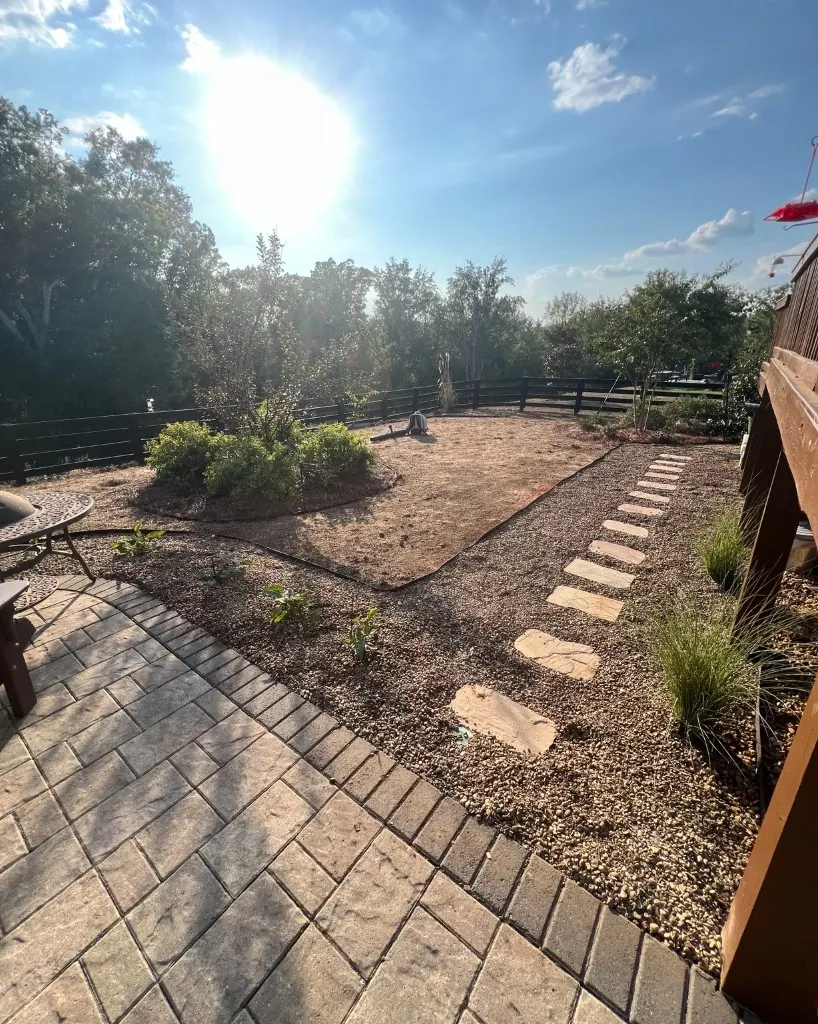 Finished College Grove backyard overall view with pea gravel stepping-stone walkway, patio edge, and landscape edging