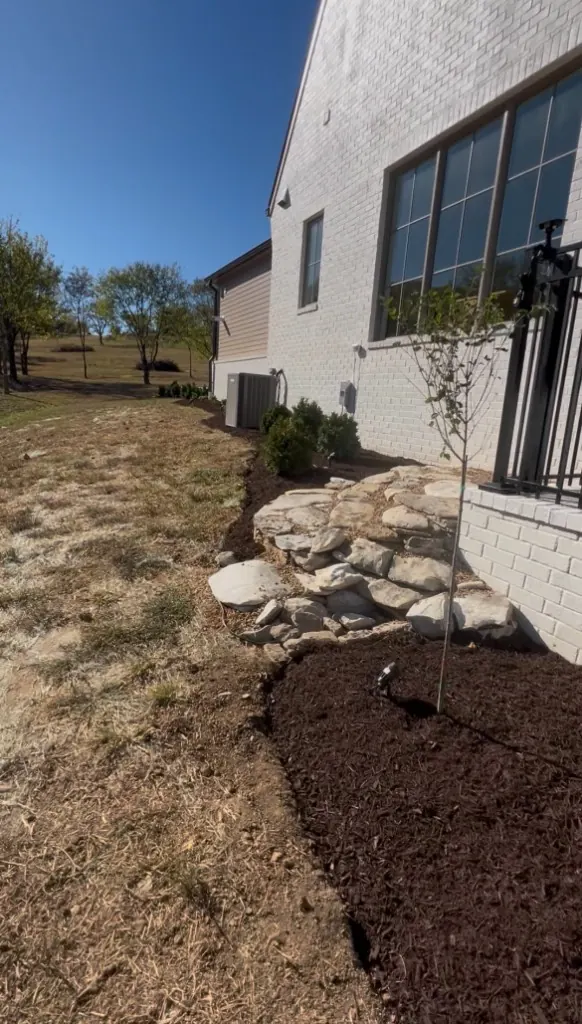 Backyard side landscape bed created and finished with brown mulch in College Grove, Tennessee