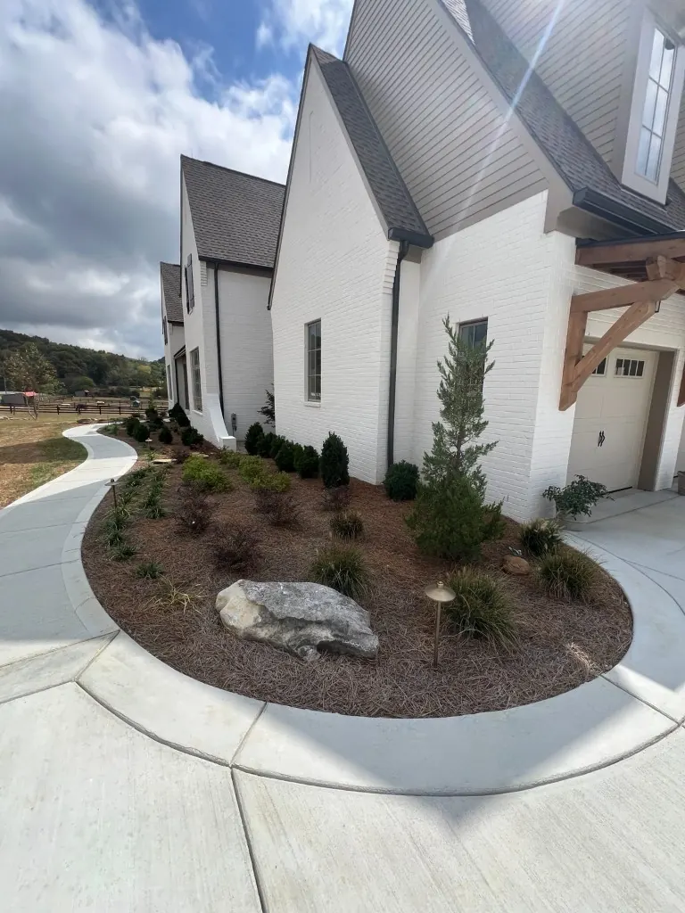 Front landscape bed with existing pine straw before cleanup in College Grove, Tennessee