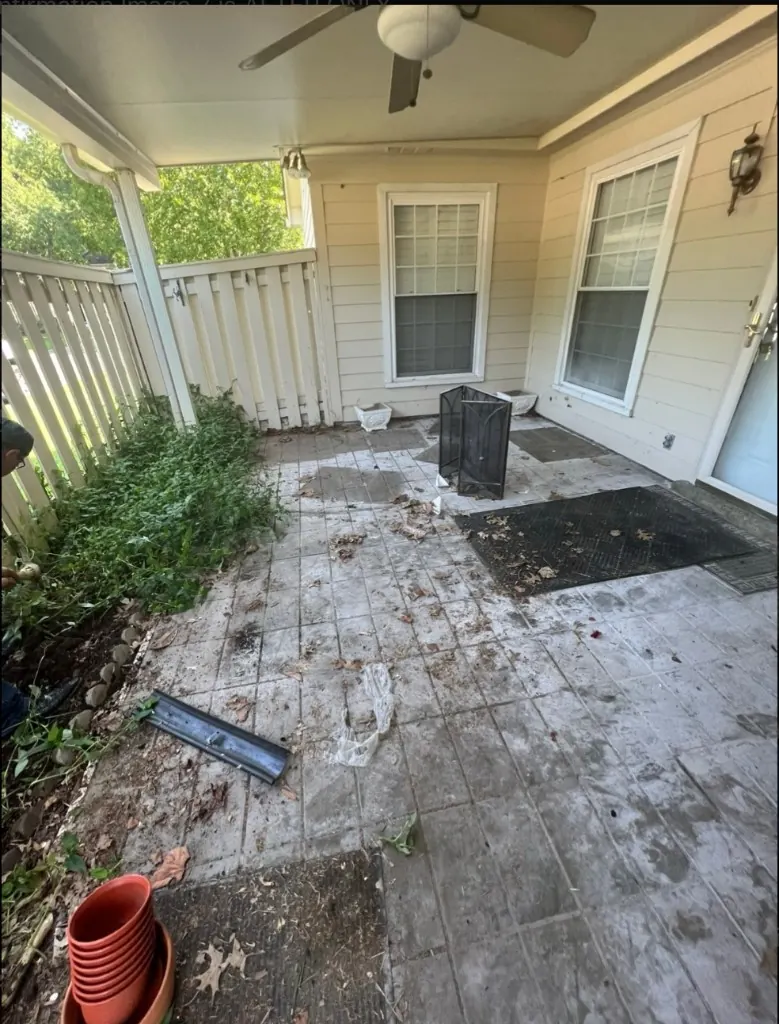 Overgrown patio landscape bed before cleanup in Franklin, TN