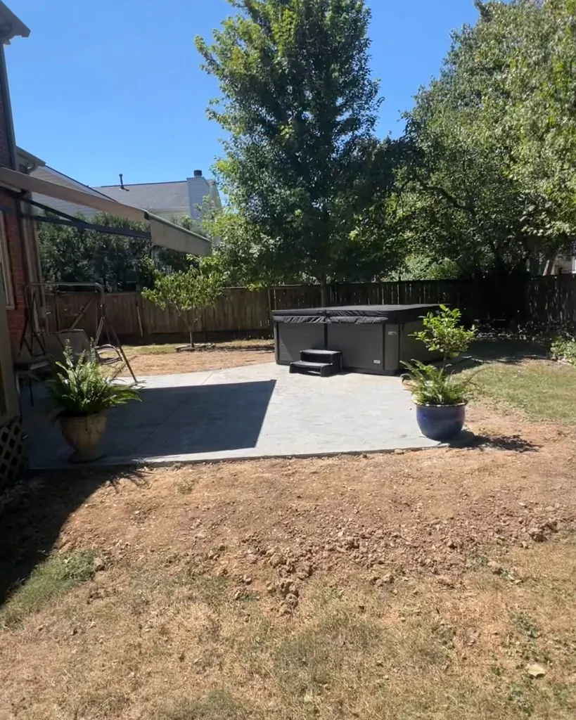 Before sod installation: bare soil and thin turf around a patio and hot tub in Franklin, Tennessee