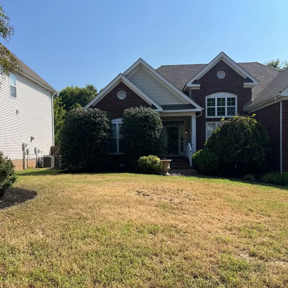Mowed front lawn and front foundation beds after property cleanup in Thompson's Station, Tennessee